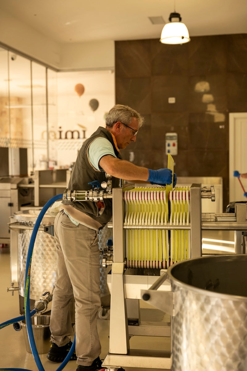 Worker adjusting filter plates at Mimì olive oil mill
