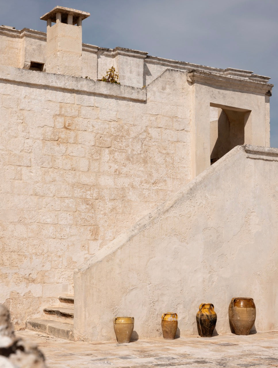 Outdoor stone staircase with row of terracotta jars at Masseria Carrassa