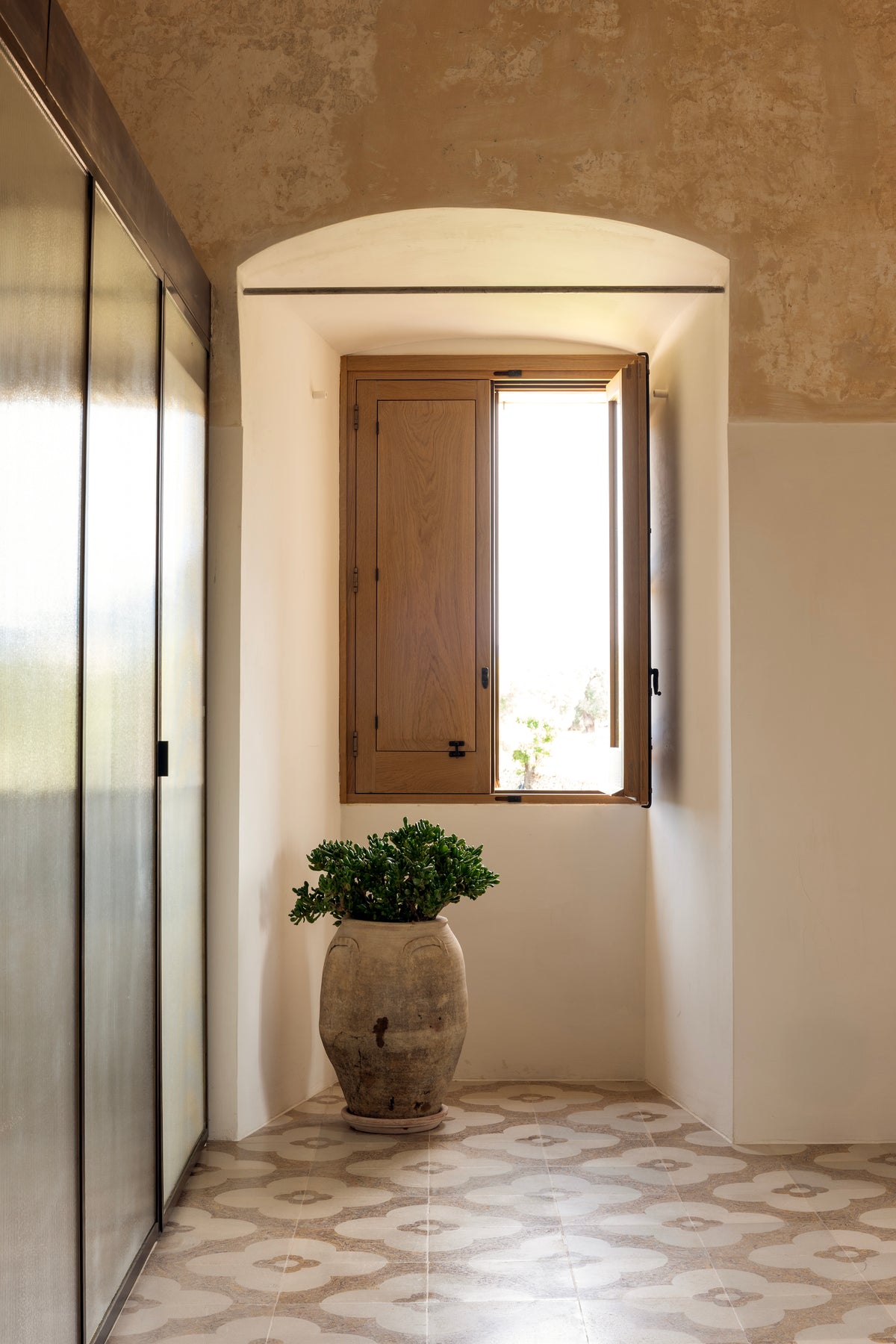 Bathroom window niche with terracotta pot and patterned tile floor