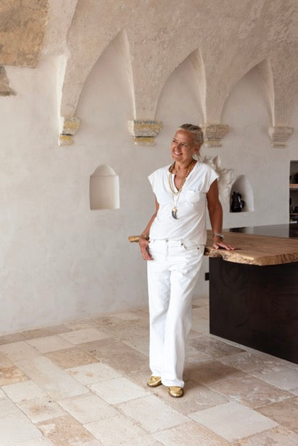 Woman standing in vaulted kitchen with arched stone niches