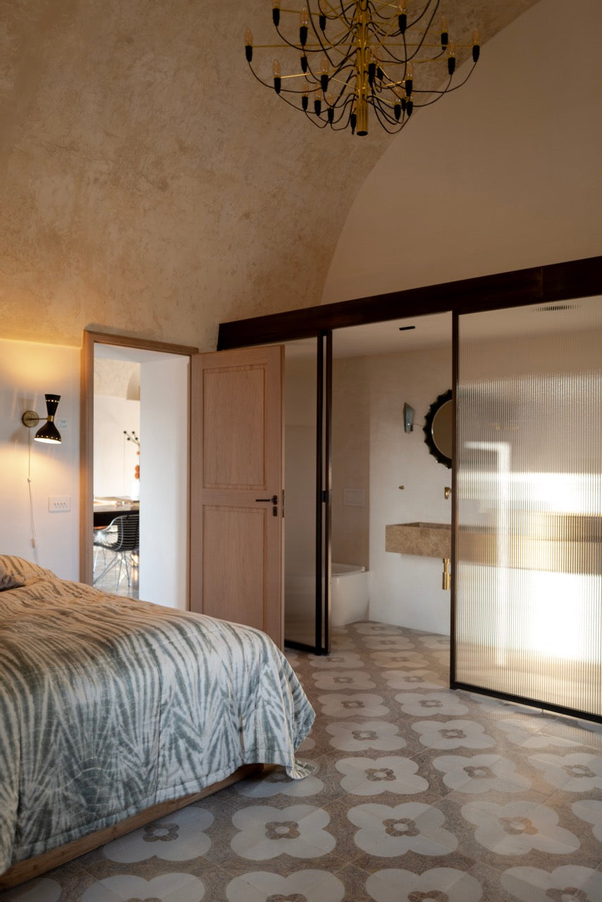 Bedroom with view into ensuite bathroom with stone sink