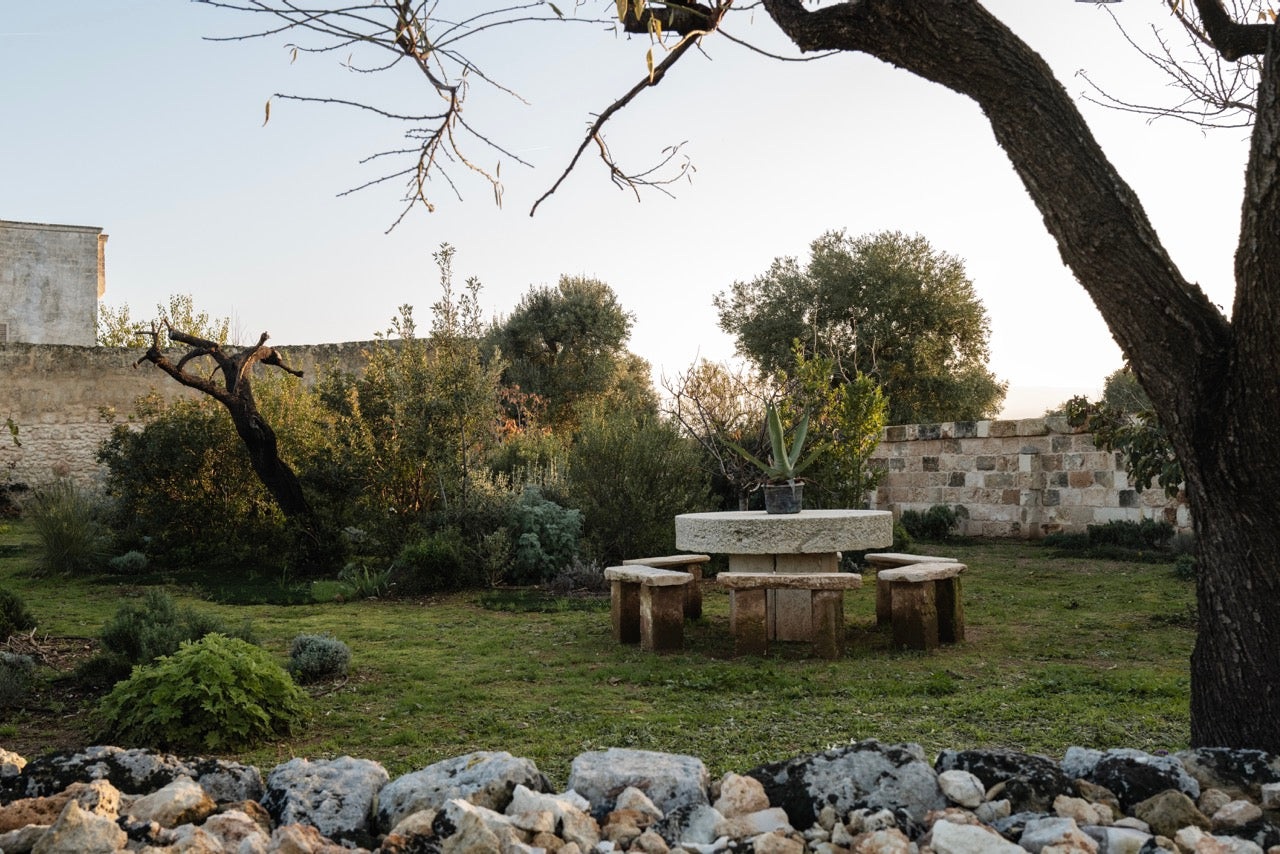 Round stone table and benches in walled orchard garden