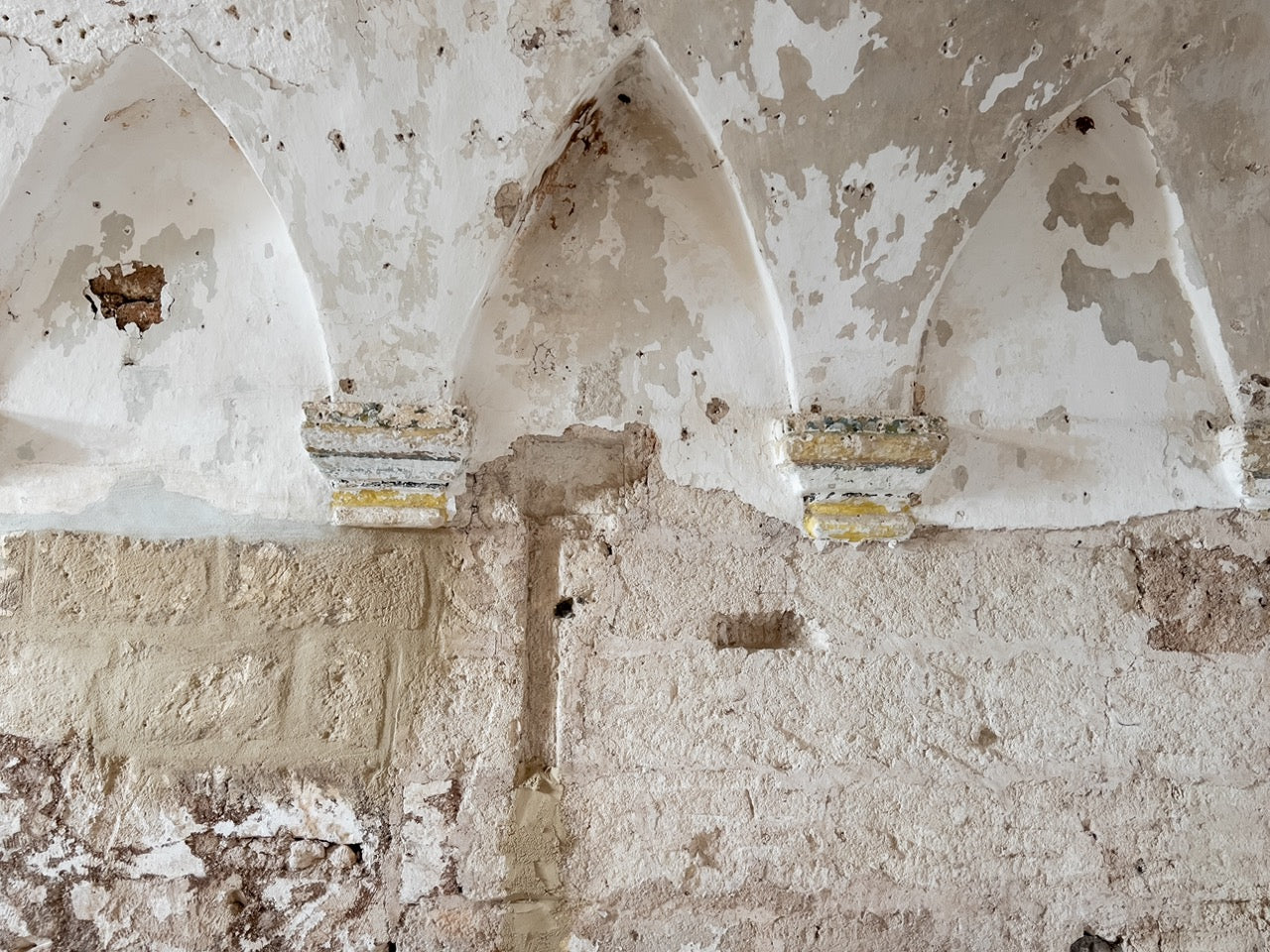 Weathered arched niches on old church wall before restoration
