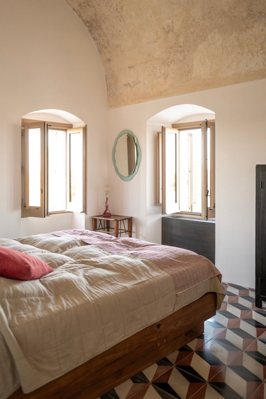 Bedroom with vaulted ceiling, arched windows and patterned tile floor