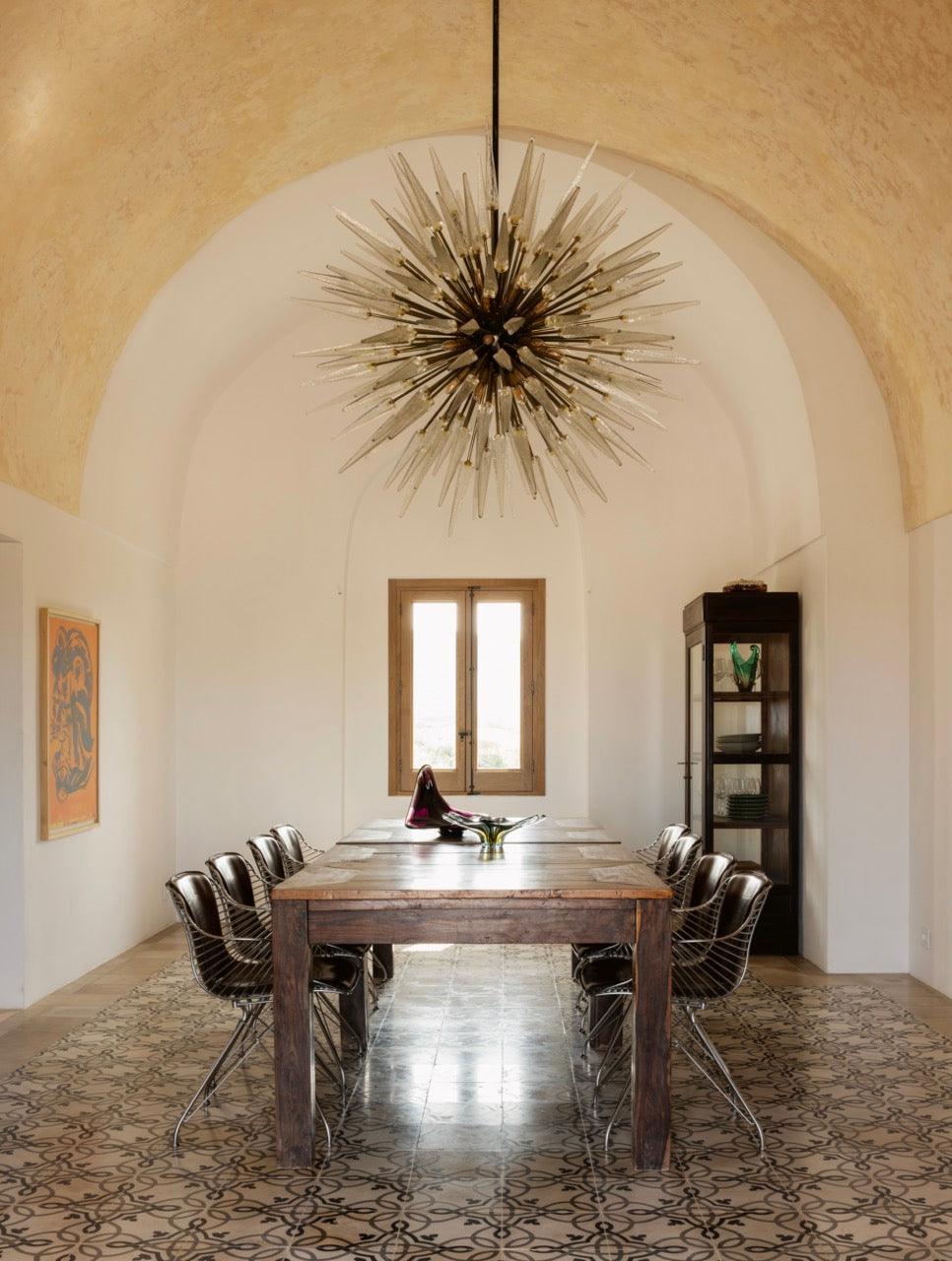 Restored vaulted dining room with long table and sputnik chandelier