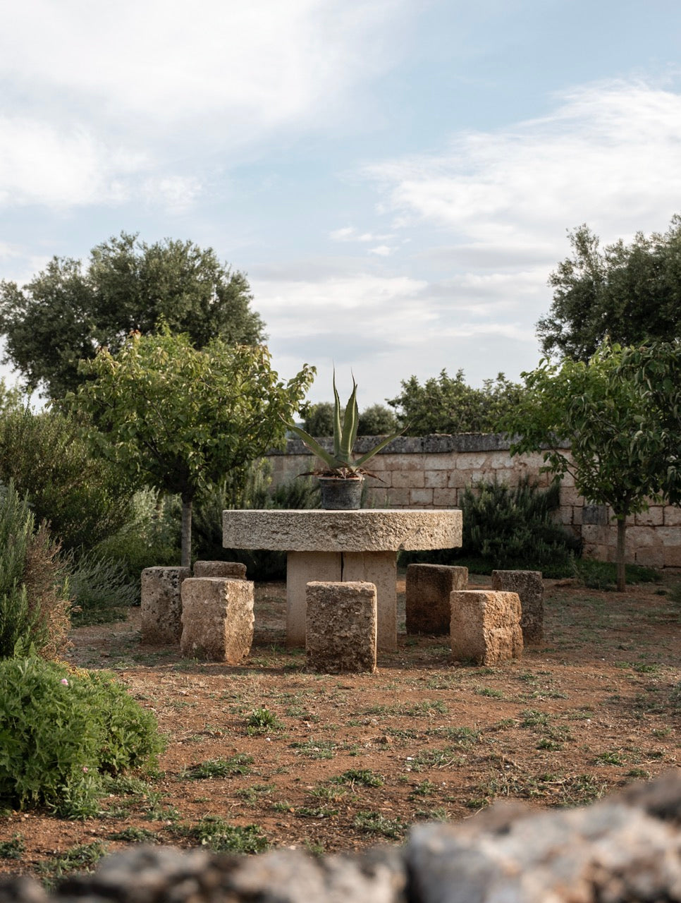 Rustic stone table and stools in olive grove garden