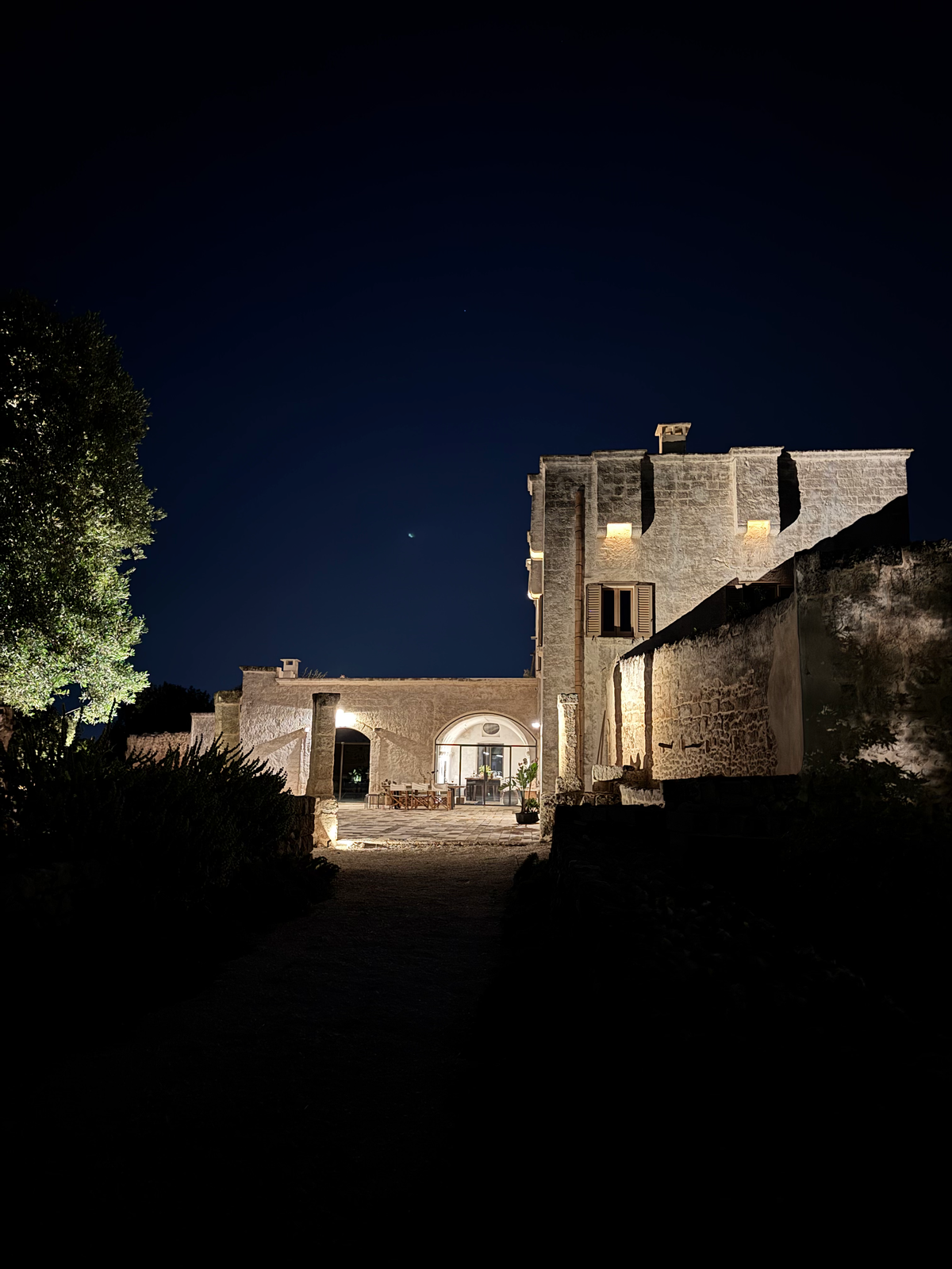 Stone masseria illuminated at night with warm lit windows