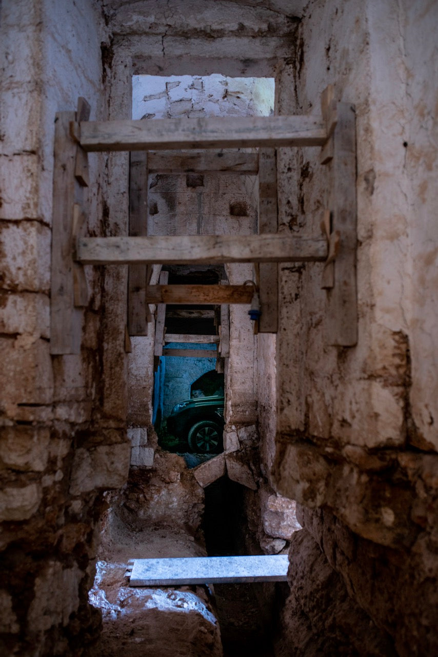 Hidden underground passage with wooden supports and stone walls
